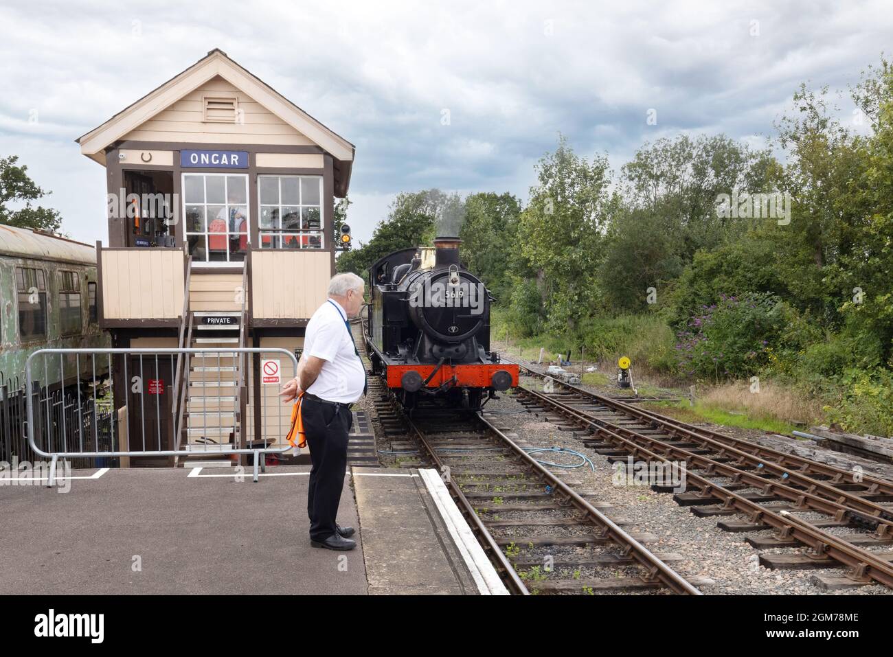 Dampfzug UK - Dampflokomotive nähert sich Ongar Station, mit Signalbox und Stationmaster in Anwesenheit, Epping-Ongar Heritage Railway Essex UK Stockfoto