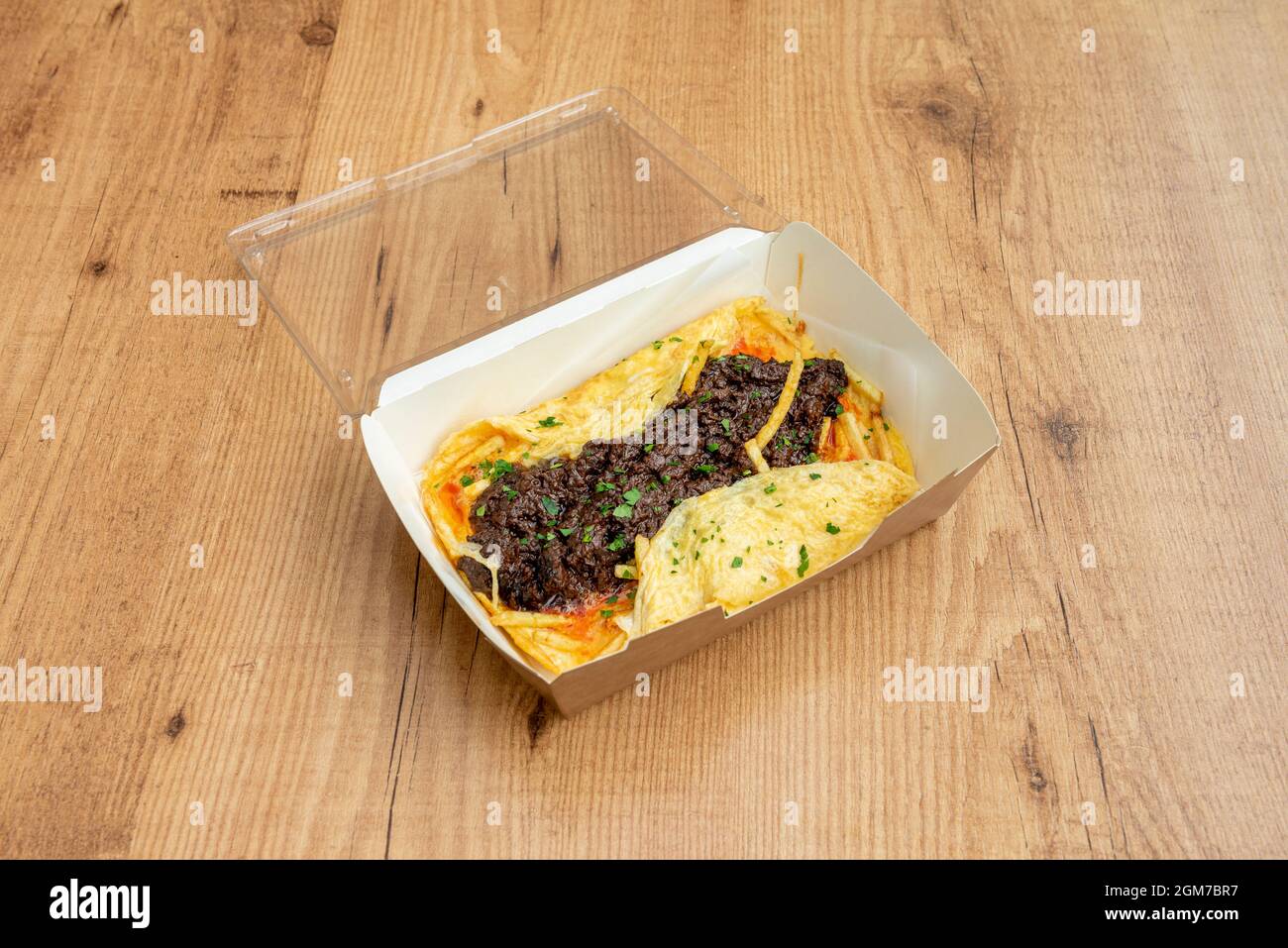 Omelette, Bratkartoffeln und Blutwurst mit Petersilie in einem Behälter mit Kunststoffdeckel zur Lieferung nach Hause Stockfoto