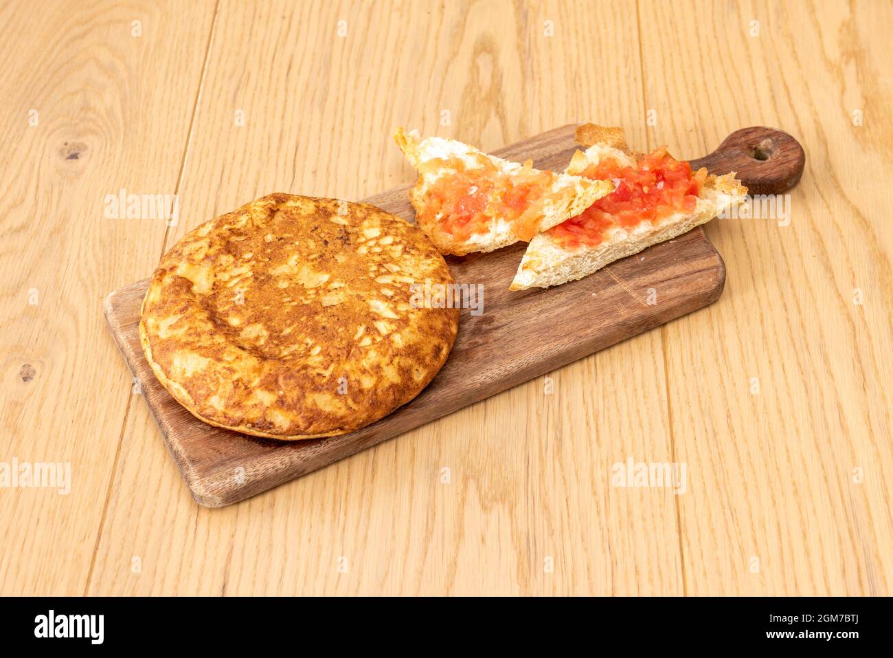 Spanisches Omelett zum Frühstück mit Tumaca-Brot auf einem Holztisch in einer spanischen Tapas-Bar Stockfoto