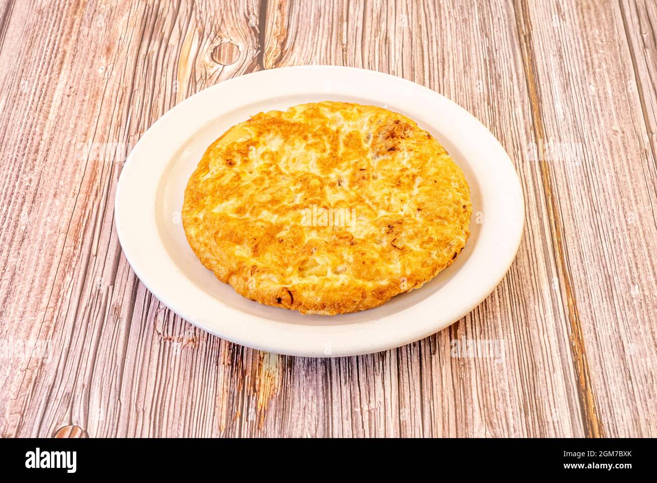 Spanisches Omelett für eine Person, gut gekräuselt auf weißem Teller zubereitet Stockfoto