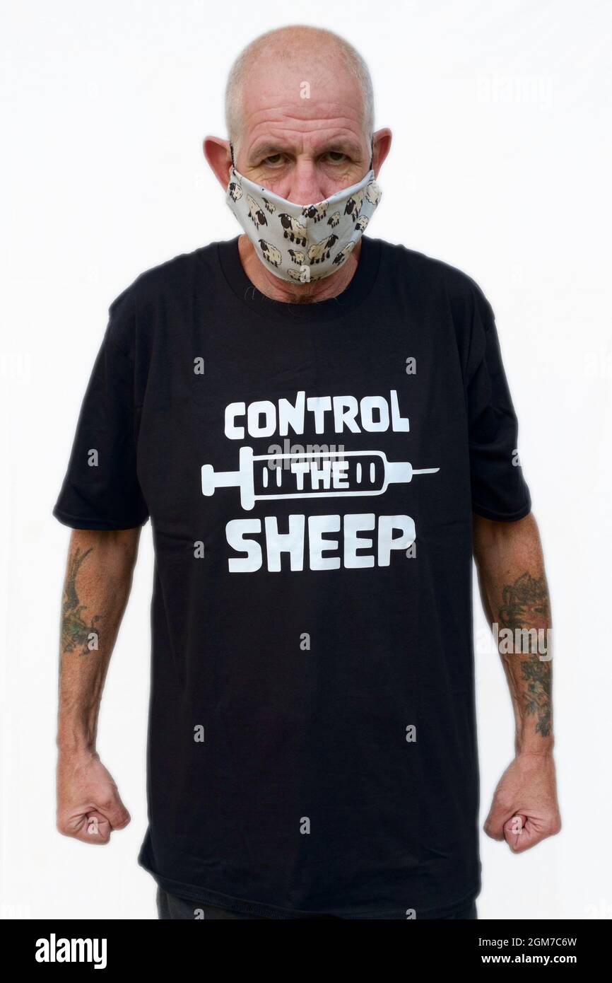 Anti-Impfstoff-Mann trägt Verschwörungstheoretiker t.Shirt und Gesichtsmaske,  die Schafe zeigt Stockfotografie - Alamy