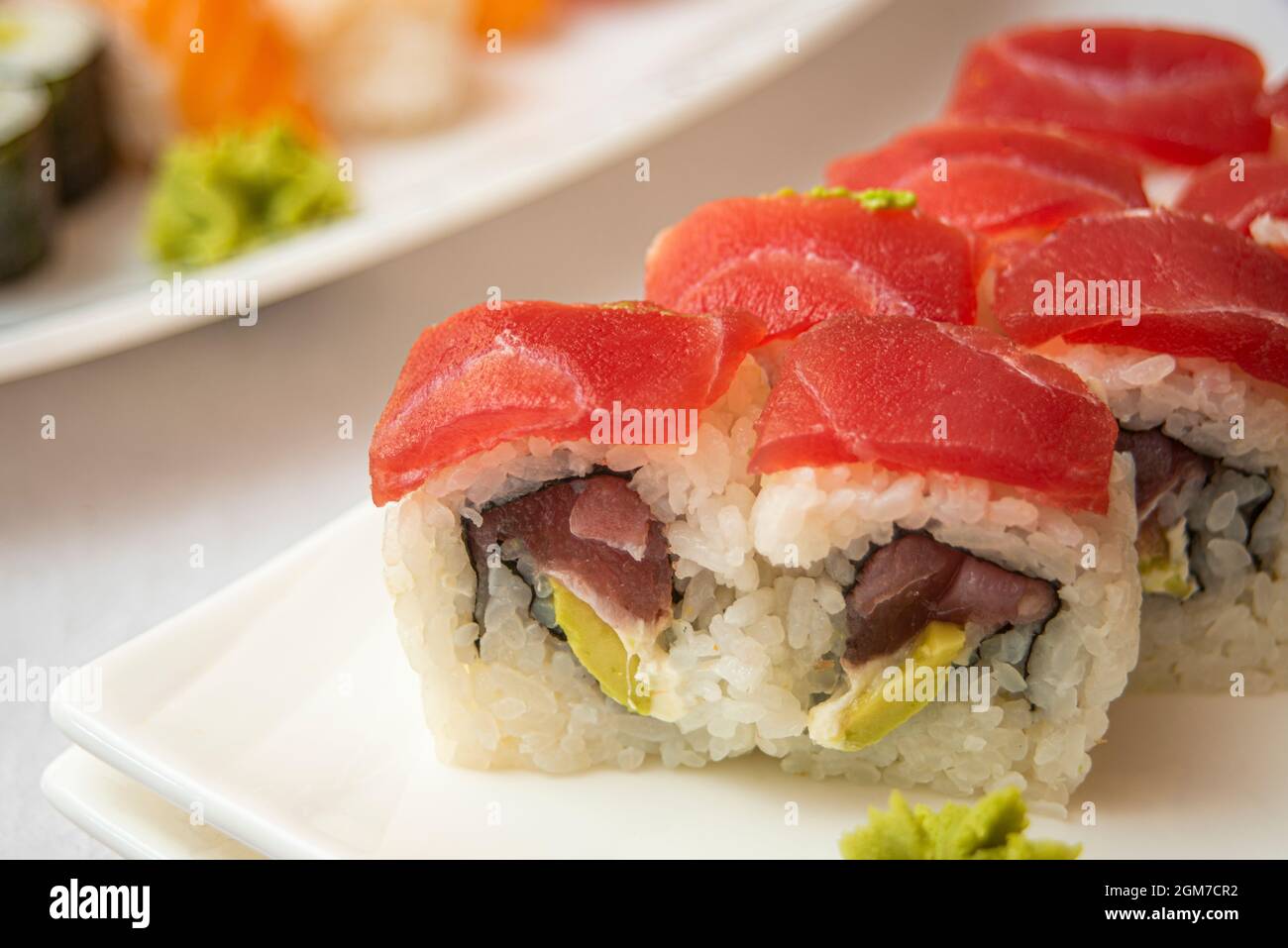 Sushi Uramaki california Roll mit rotem Thunfisch, reifer Avocado, Frischkäse und Nori-Algen mit Wasabi Stockfoto