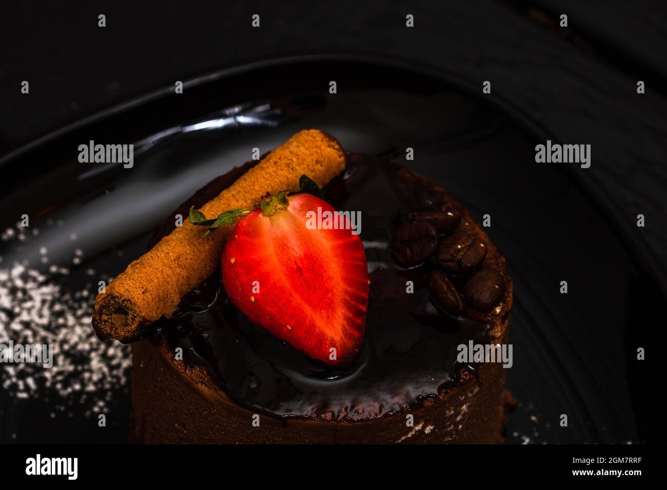 Nahaufnahme des Schokoladenmousse-Nachtisches. Schokoladenkuchen mit Erdbeere und Zimt. Stockfoto