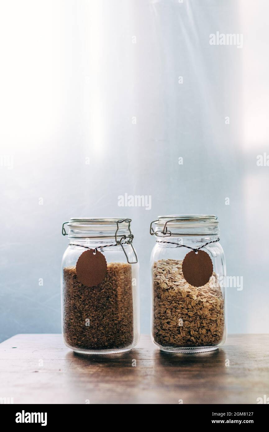 Gesunde ballaststoffreiche Lebensmittel mit niedrigem glykämischen Index - Frühstück Haferflocken und brauner Reis in Gläsern Stockfoto