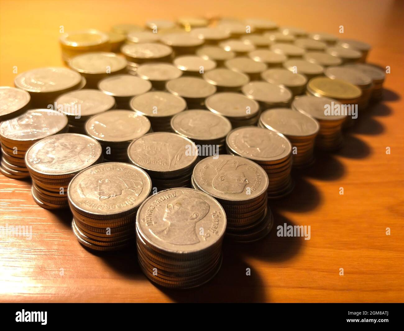 Thai Baht Münzen Stapel mit weichem Licht Hintergrund. Thailändische Münze im Konzept der Finanzierung, Safe Money. Stockfoto