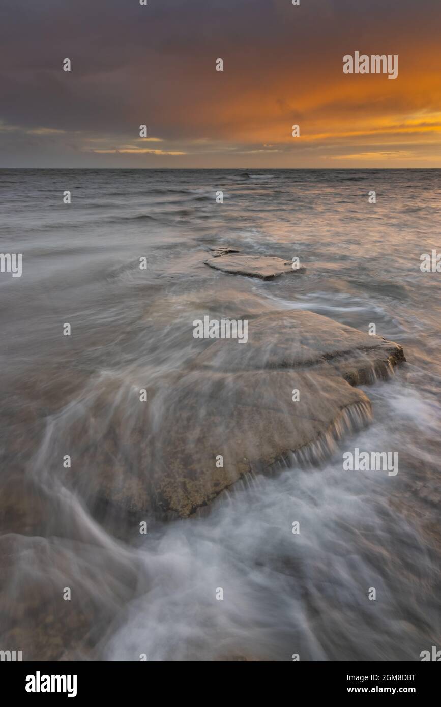 Sonnenuntergang im Sommer, wenn die Flut einströmt, Kimmeridge Bay, Dorset. Jurassic Coast Stockfoto