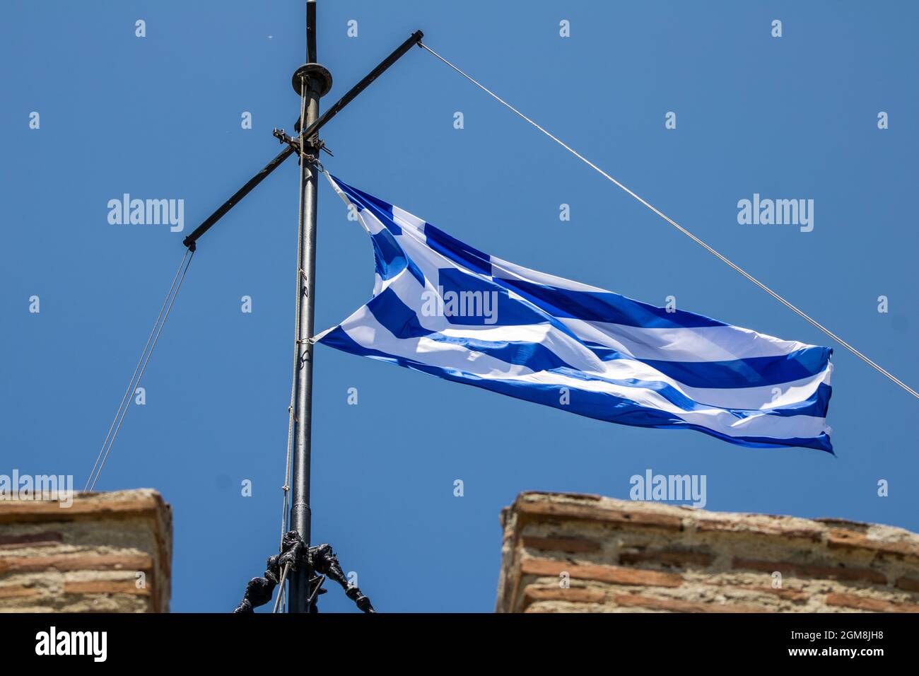 Griechische Flagge im Wind auf dem Weißen Turm, Sehenswürdigkeit der Stadt Thessaloniki Griechenland Stockfoto