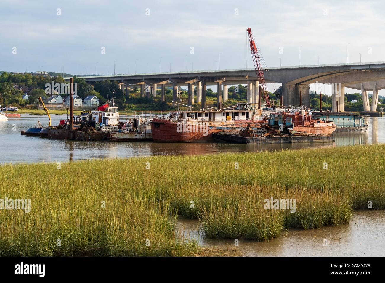 Low Tide, am späten Nachmittag Medway Estuary in Rochester in Kent mit Bootsreparatoren schwimmende Dock im Bild mit M2 Medway Bridge im Hintergrund Stockfoto