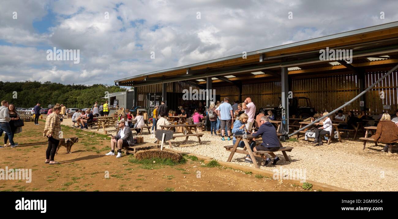Chipping Norton, Oxfordshire, England, Großbritannien. 2021. Die Scheune und die Kunden essen und trinken von der Bar im Diddly Squat Farm Shop in der Nähe von Chipping Norton i Stockfoto