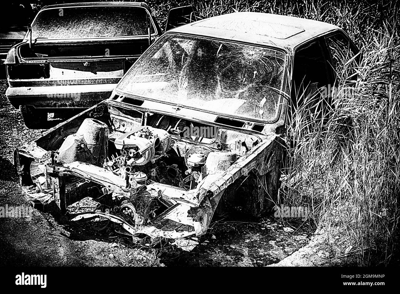 Zerbrochener und zerlegter Wagen nach einem Unfall ohne Haubenabdeckung in schwarz-weißem Stil Stockfoto