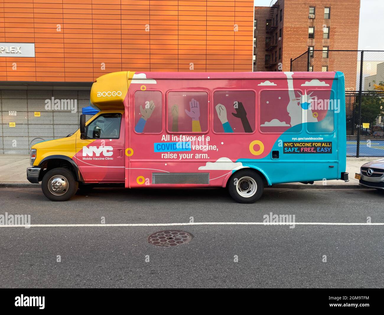 New York City investiert Millionen von Dollar und drängt darauf, alle Menschen geimpft zu bekommen, wie diese farbenfrohe „NYC Mobil Vaccine Clinic“ zeigt, die am Morgen vor einer öffentlichen Schule geparkt ist, als Eltern Kinder in die Schule im Stadtteil Windsor Terrace in Brooklyn, New York, bringen. Stockfoto