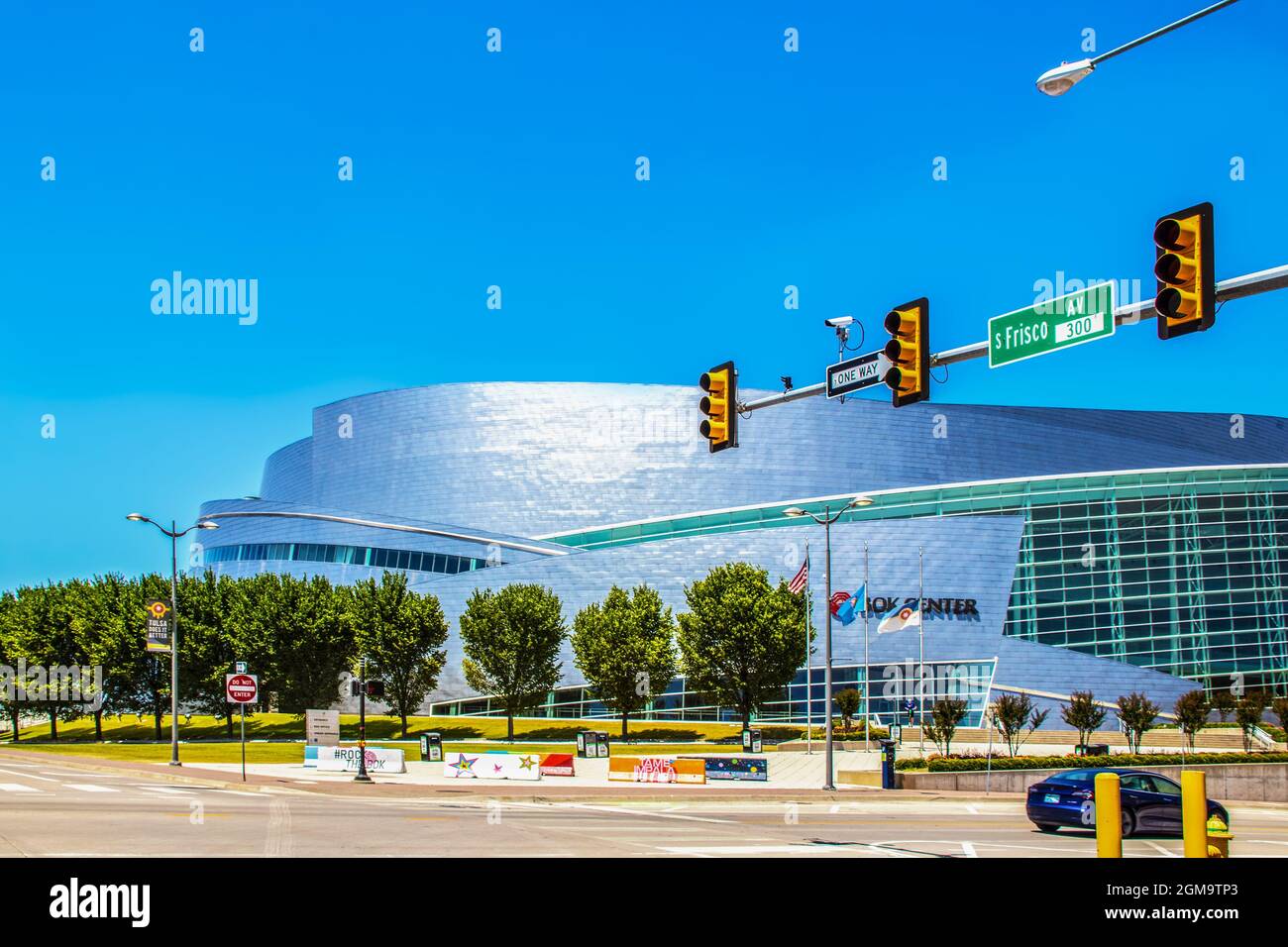 06-13-2020 Tulsa USA BOK Center mit USA Oklahoma und Tulsa Flaggen und Straßenecke und Junge auf dem Roller Stockfoto