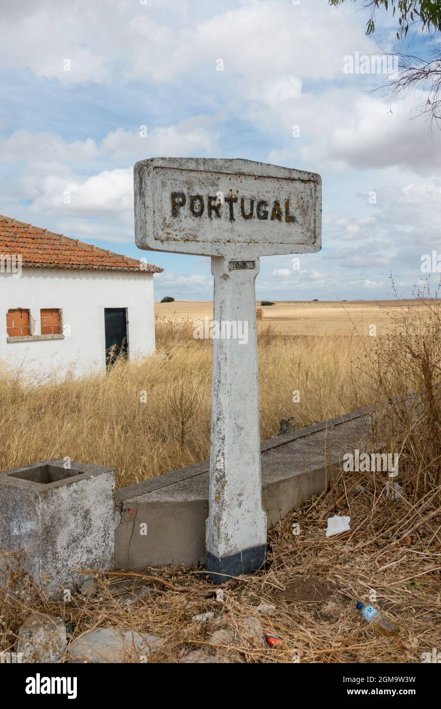 Altes Steinschild an der portugiesischen Grenze zu Spanien bei Badajoz. Altes verlassenes Grenzkontrollhaus. Stockfoto