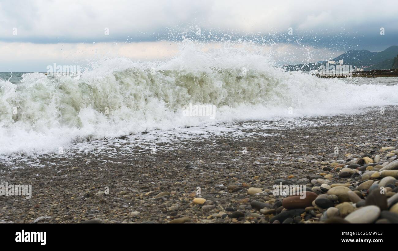 Große Sturmwellen an einem Kiesstrand Stockfoto