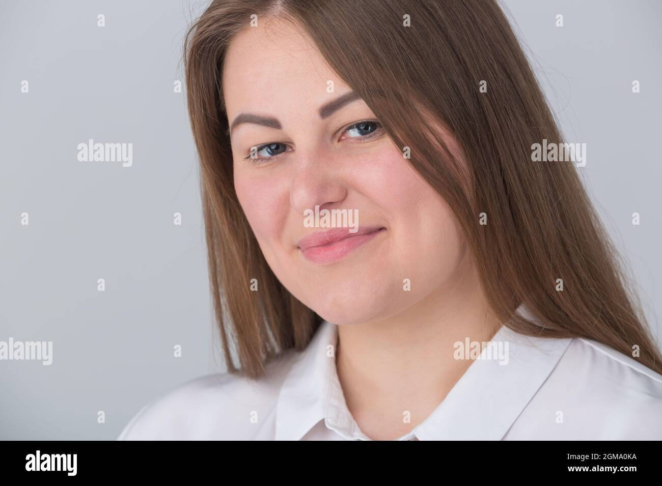 Schöne übergewichtige junge Frau lächelt in der Kamera auf Studioportrait. Plus Size weibliche Porträt. Stockfoto