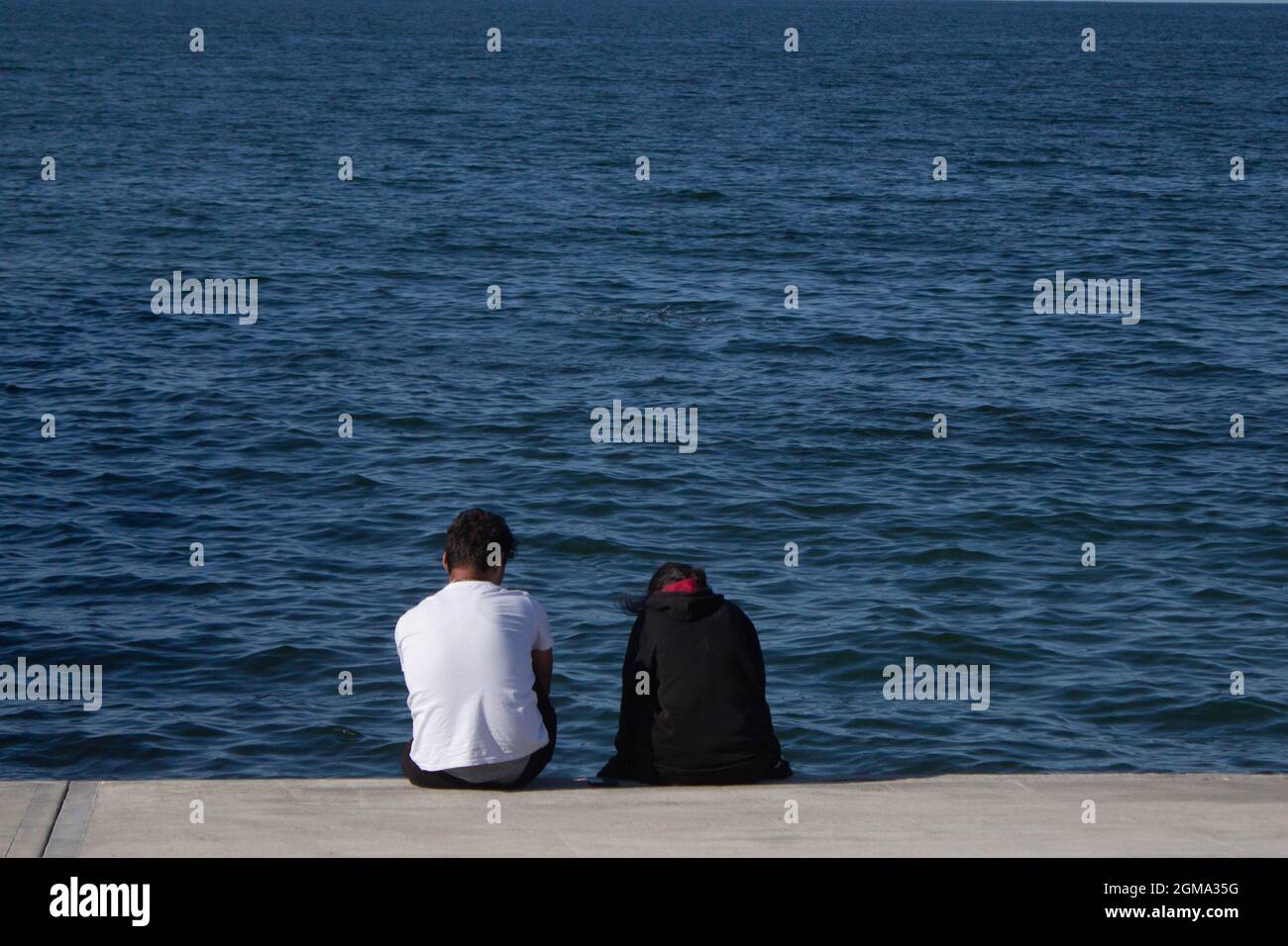 Junges Paar vor dem Meer. Flitterwochen Pläne. Glückliche Frau glückliches Leben. Stockfoto