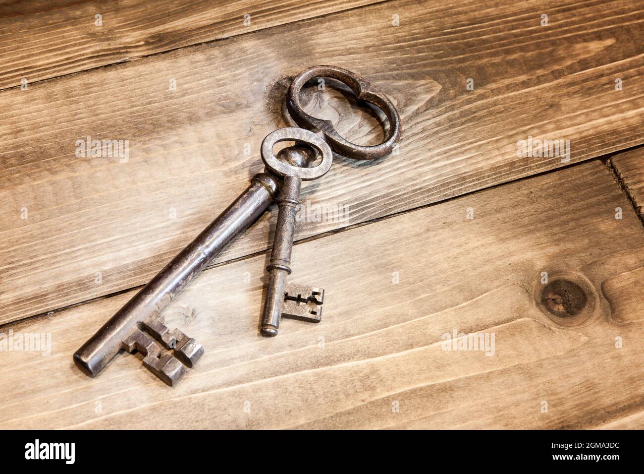 Zwei alte Schlüssel liegen auf verwittertem Holz Stockfoto