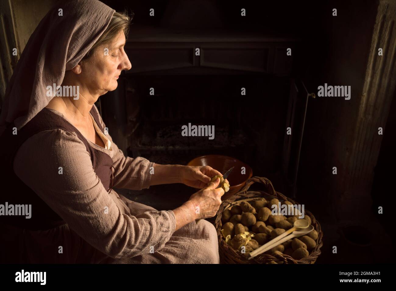 Renaissance der alten Meister Porträt einer Bäuerin Schälen von Kartoffeln an ihrem Kamin Stockfoto