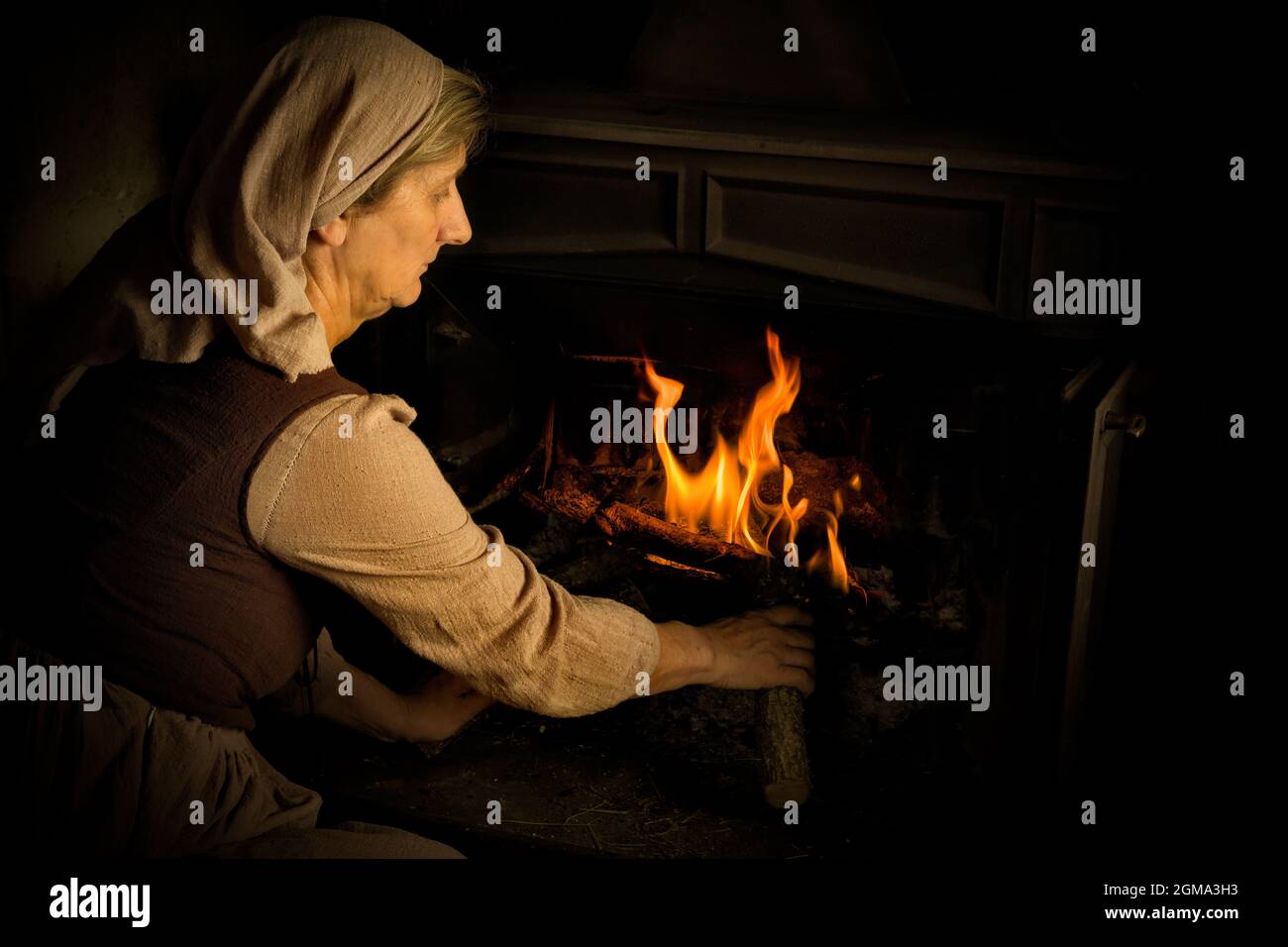 Renaissance alten Meister Porträt einer Bauernfrau Holz hinzufügen Zu einem brennenden Feuer Stockfoto