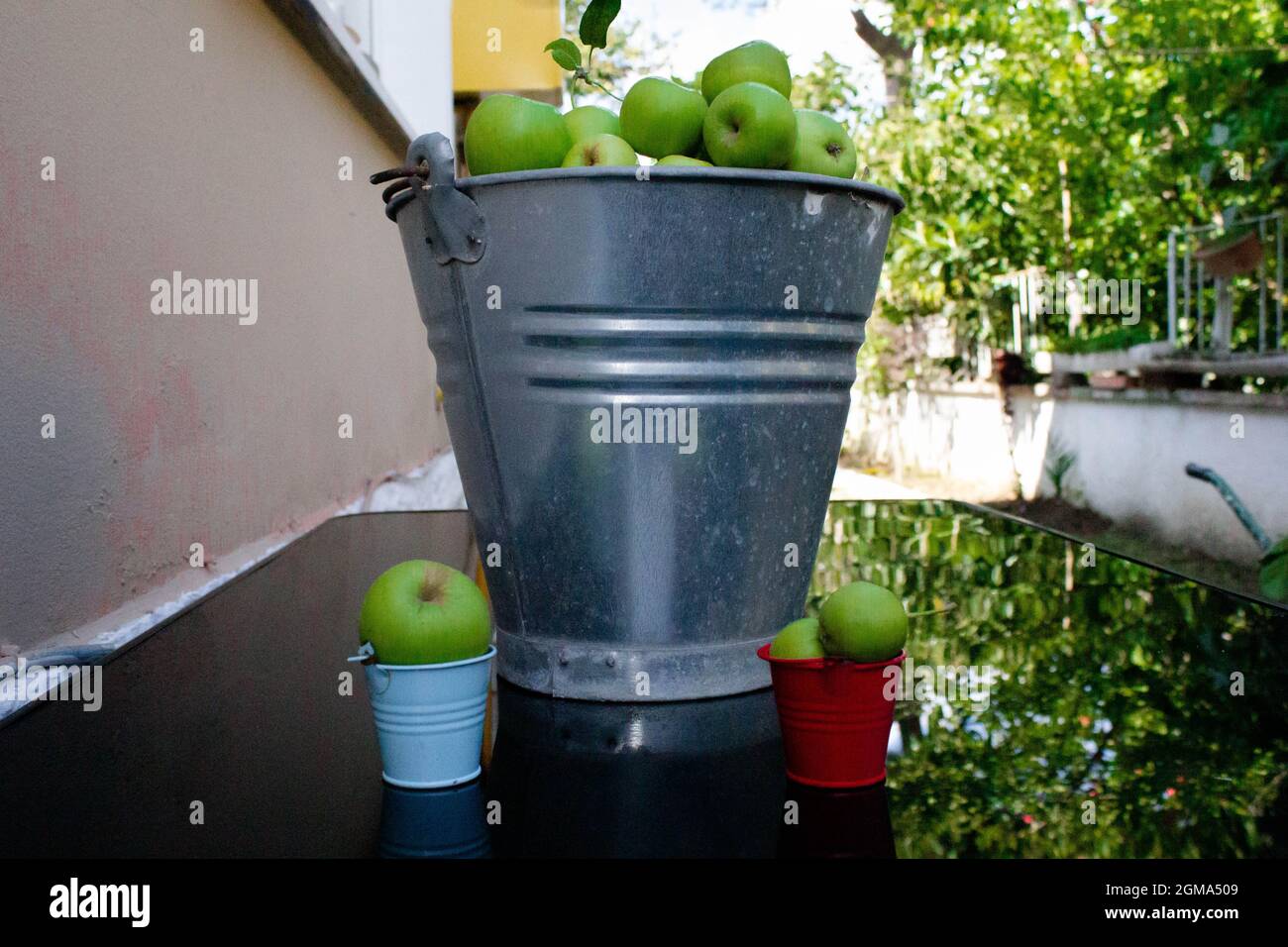 Äpfel in Eimern. Der Anteil der Menschen hängt mit ihrer Anstrengung zusammen. Anstrengung ist Geld. Wie viel man so viel steckt, bekommt man. Stockfoto