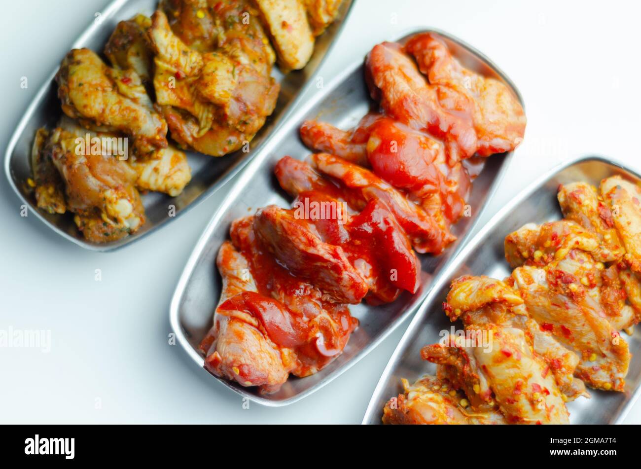 Drei verschiedene Set der Hähnchenflügel mit sriracha Glasur, karibische Marinade und chinesische Glasur, Mahlzeiten Weltküche zubereitet zu kochen Stockfoto