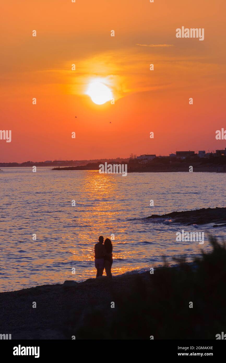 Liebevolles Paar beim Sonnenuntergang am Strand: Apulien ionisches Meer in Italien. Stockfoto
