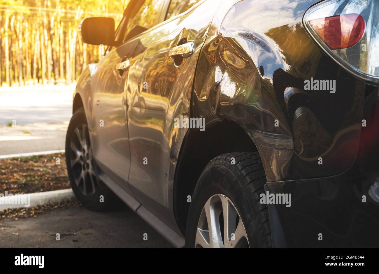 Das schwarze Auto wurde nach einem Unfall auf der Straße zerstört. Kaputtes Auto auf dem Parkplatz Stockfoto