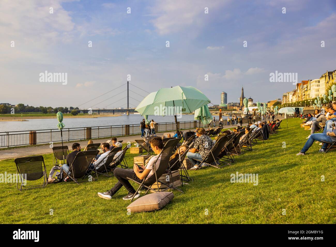 Restaurant oder Bar im Freien mit Liegestühlen und Sonnenschirmen am Rheinufer in Düsseldorf, Deutschland, Europa Stockfoto