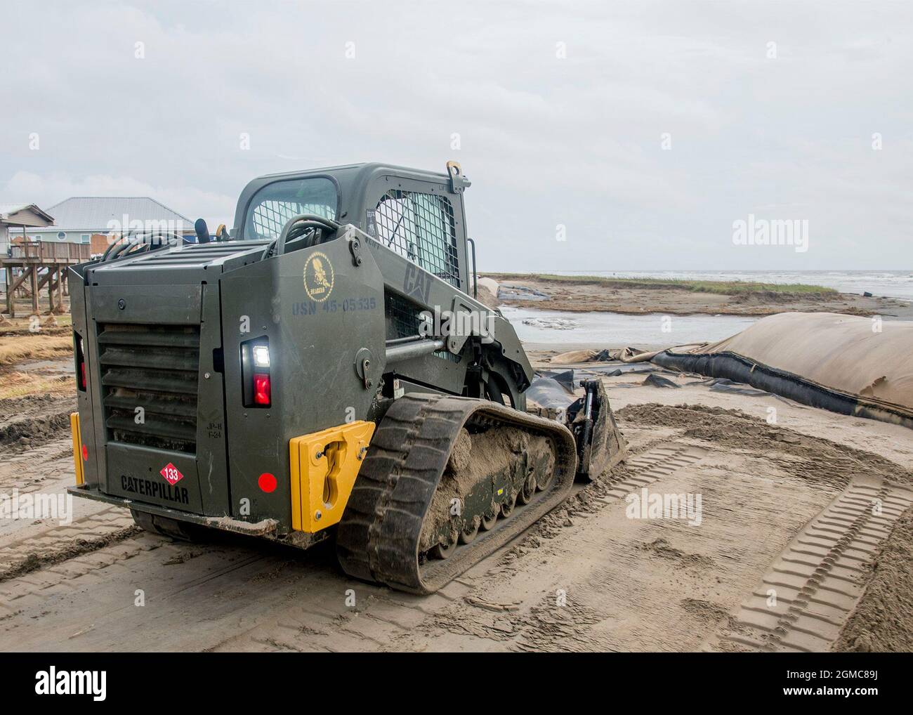 Der Konstrukteur Jon Tinney, der dem Naval Mobile Construction Bataillon (NMCB) 133 zugewiesen wurde, betreibt einen Gleitlenker, um Sand zu entfernen, um bei Straßenrenkungsarbeiten während der Katastrophenhilfe des Hurrikans Ida in Grand Isle zu helfen, La. NMCB 133 arbeitet neben seinen Schwesterdiensten als einziges Element der Marine zur Unterstützung der Katastrophenhilfe. Die Mission des NMCB 133 besteht darin, eine anpassungsfähige und skalierbare Naval Construction Force bereitzustellen, die eine wesentliche Komponente der US-Seeverkehrsstrategie bei der Ausführung hochwertiger Baumaßnahmen im Kampf, bei humanitärer Hilfe oder bei Katastrophenabwehr darstellt. Stockfoto