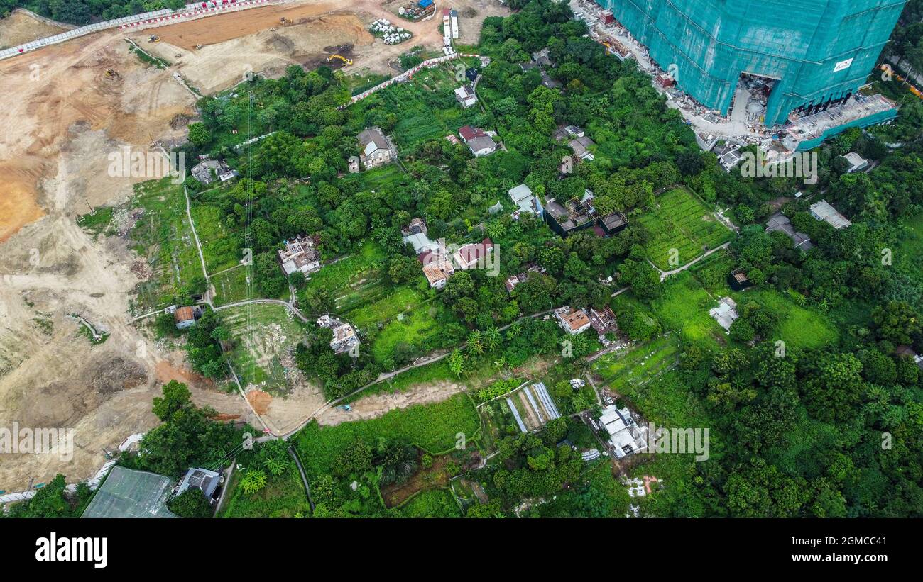 Hongkong, China. September 2021. (ANMERKUNG DER REDAKTION: Bild aufgenommen mit einer Drohne)Luftaufnahme von geteiltem Ackerland, Dorfhäusern, Entwicklungsland und einem Gebäude, das während der Räumung gebaut wird. Mehr als ein Dutzend Mitarbeiter der Landverwaltung, Auftragnehmer und Bauarbeiter kamen im Dorf Ma Shi Po an, um Land aus dem letzten verbliebenen Haus zurückzugewinnen. Die lokalen Landwirte stehen seit Anfang der 2000er Jahre vor einer drohenden Räumung. Kredit: SOPA Images Limited/Alamy Live Nachrichten Stockfoto