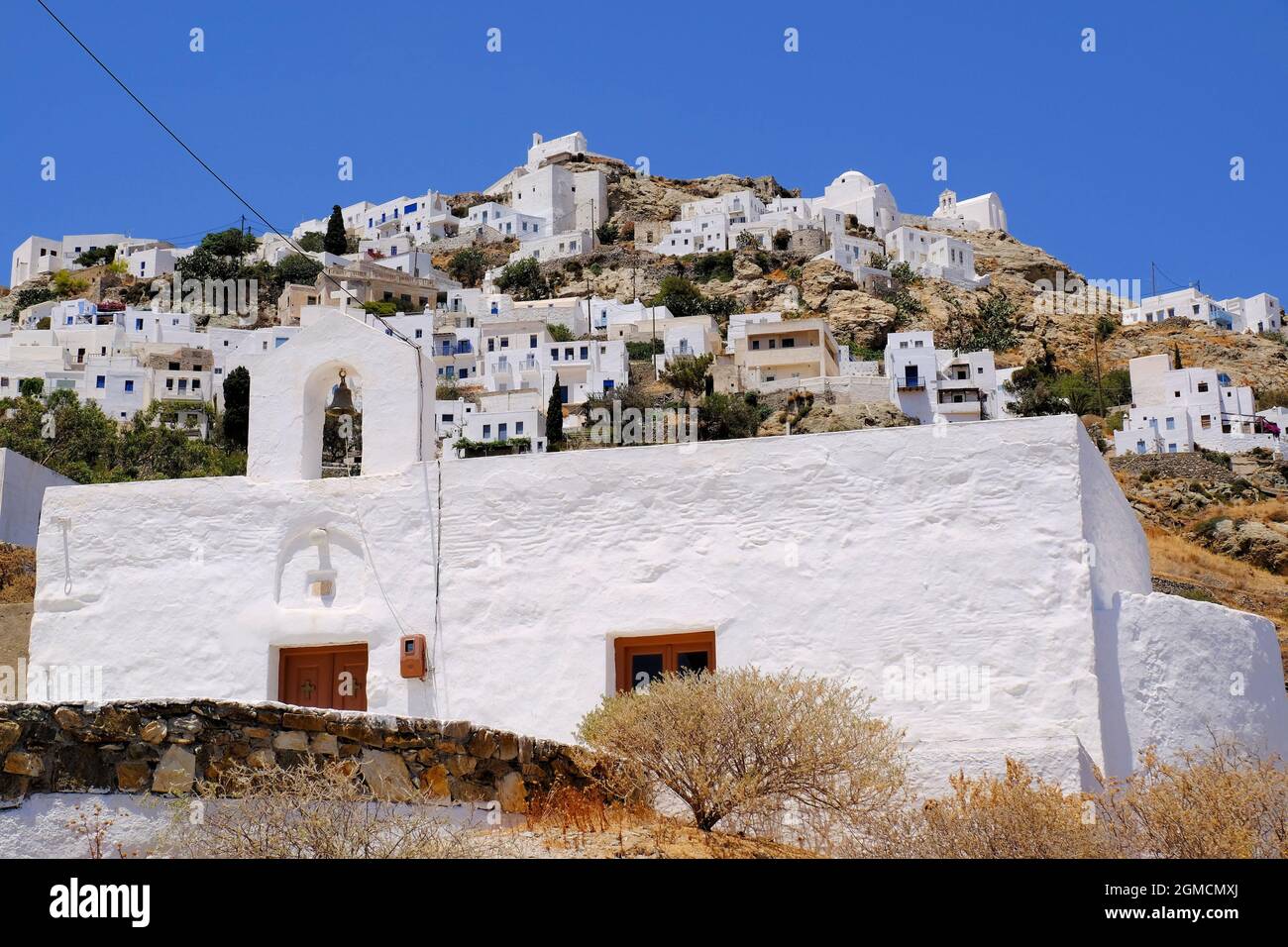 Blick auf Serifos Chora und seine weißen Kapellen und Gebäude mit einer einfachen Kirche im Vordergrund auf Serifos Island, Kykladen, Griechenland Stockfoto