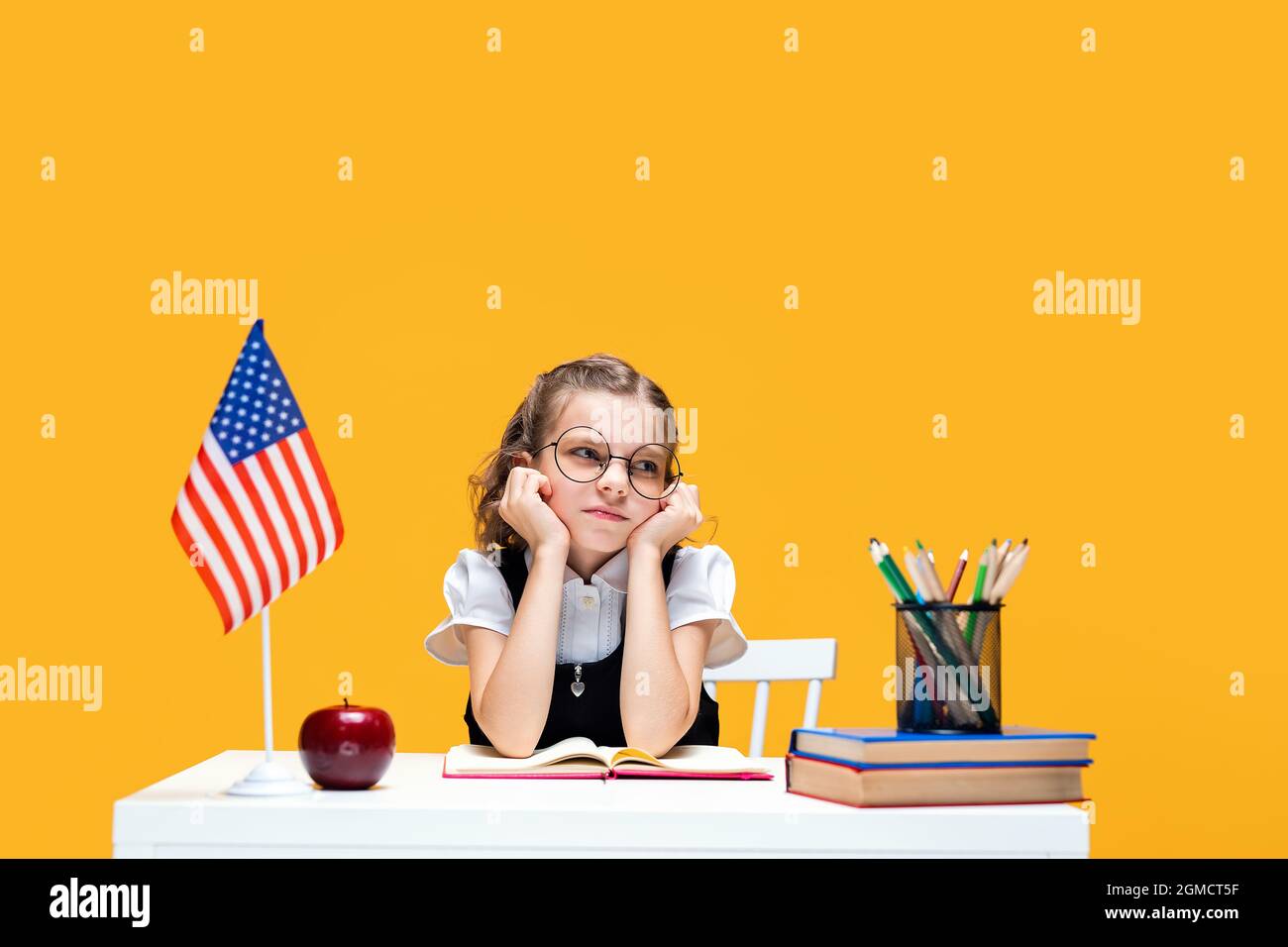 Traurig langweilig kaukasischen Schülerin in Brille studieren zu Hause. Englischunterricht. USA-Flagge Stockfoto