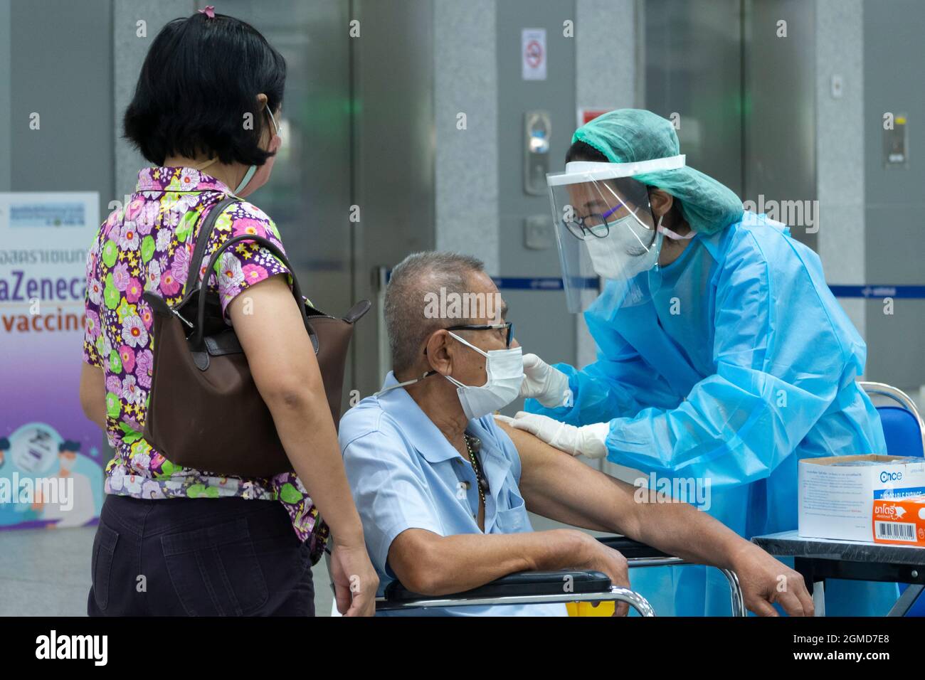 Bangkok, Thailand - September 17, 2021 : Asian Arzt oder Krankenschwester geben covid Antivirus-Impfstoff Schuss an ältere Mann Patient trägt Schutzmaske Gesicht Stockfoto