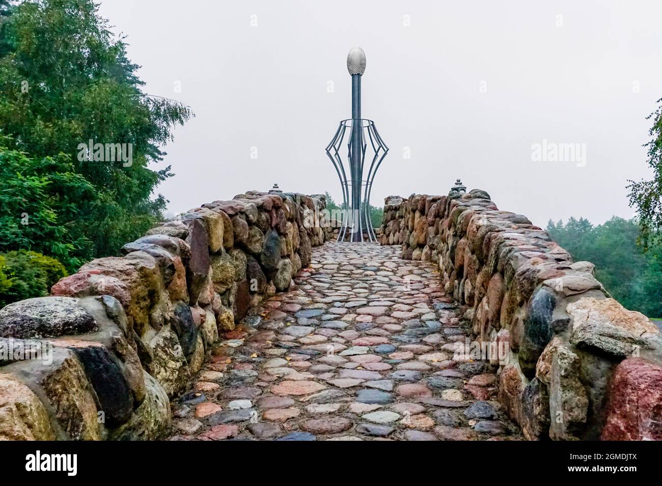 Merkine, Litauen - 31. August 2021: Steinweg, der zu einer neuzeitlichen Statue des Glaubens und der Energie in der Pyramide der Merkine-Gärten führt Stockfoto