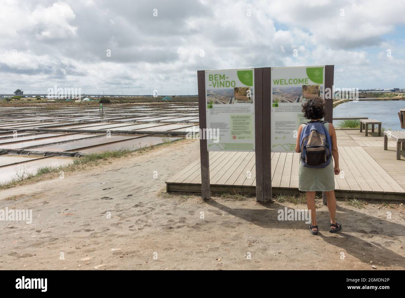 Frau, die vor der Informationstafel des Freilichtmuseums Eco Museum, Aveiro salinas, Salzpfannen in der Stadt Aveiro, Portugal, steht Stockfoto