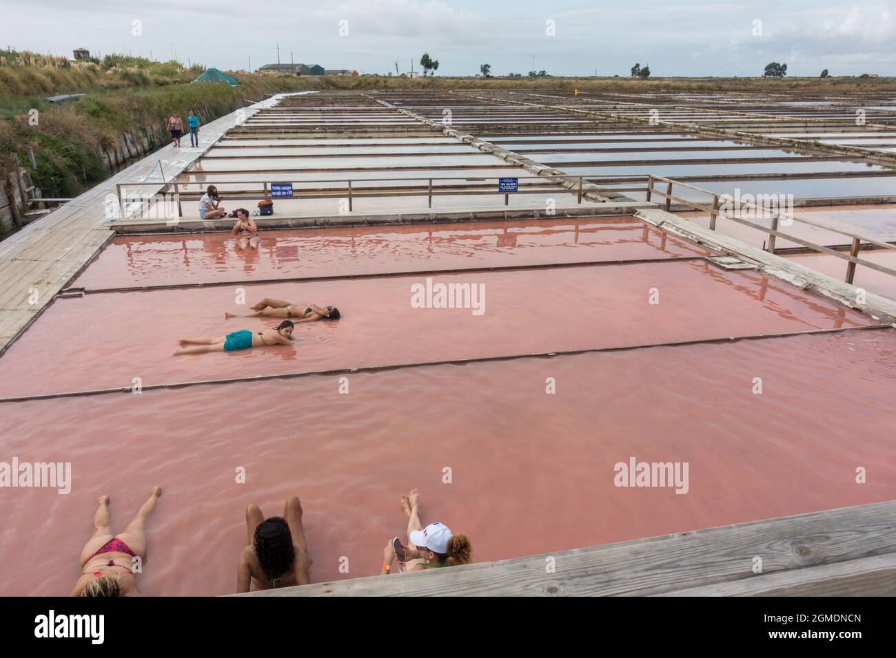 Menschen, die in den Salinen von Aveiro, Portugal, ein Salz- und Schlammbad nehmen. Stockfoto