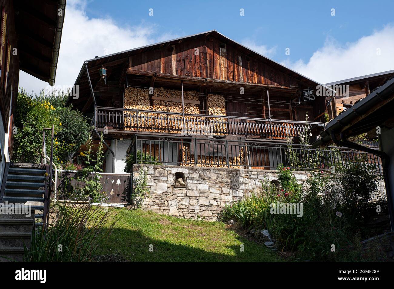 Holzchalet mit einem Haufen Feuerholz draußen Stockfoto