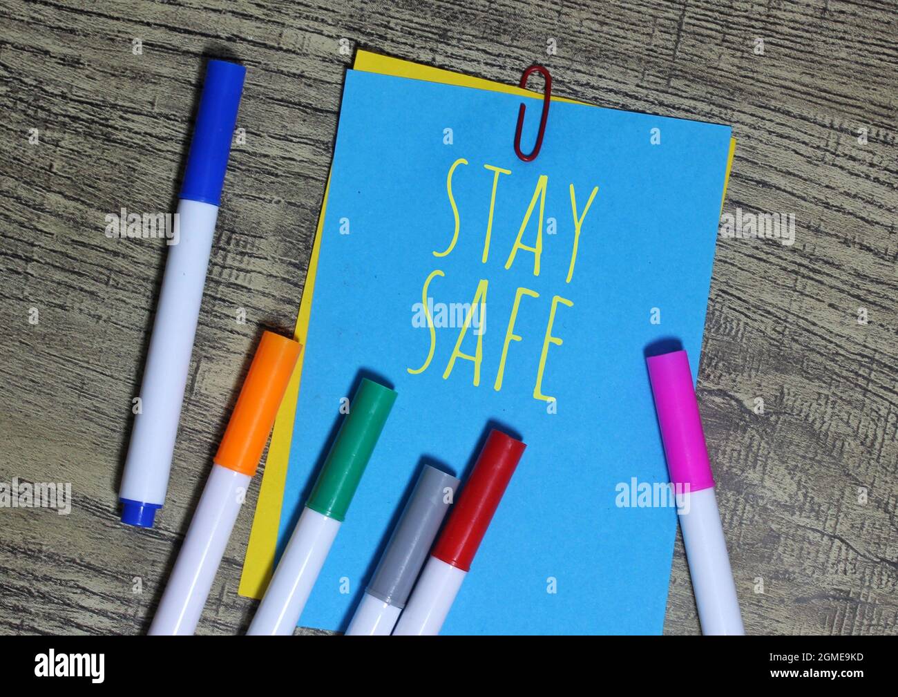 Die Ansicht von oben auf farbigem Notizpapier, umgeben von einem bunten Stift mit Text, IST SICHER. Stockfoto