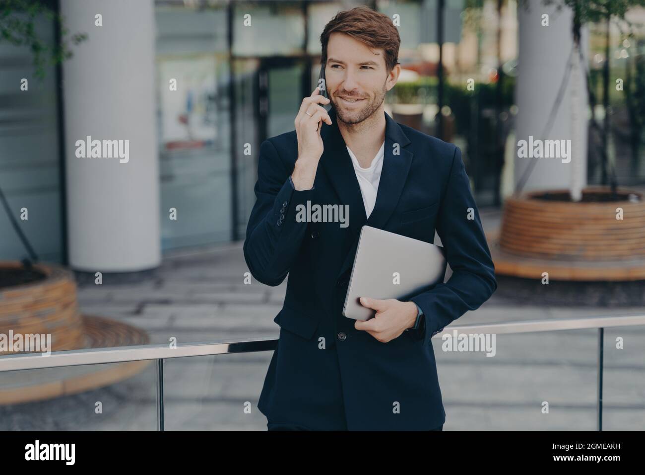 Die Geschäftsführerin im Hotel hat formelle Kleidung, die im Freien mobil spricht Stockfoto