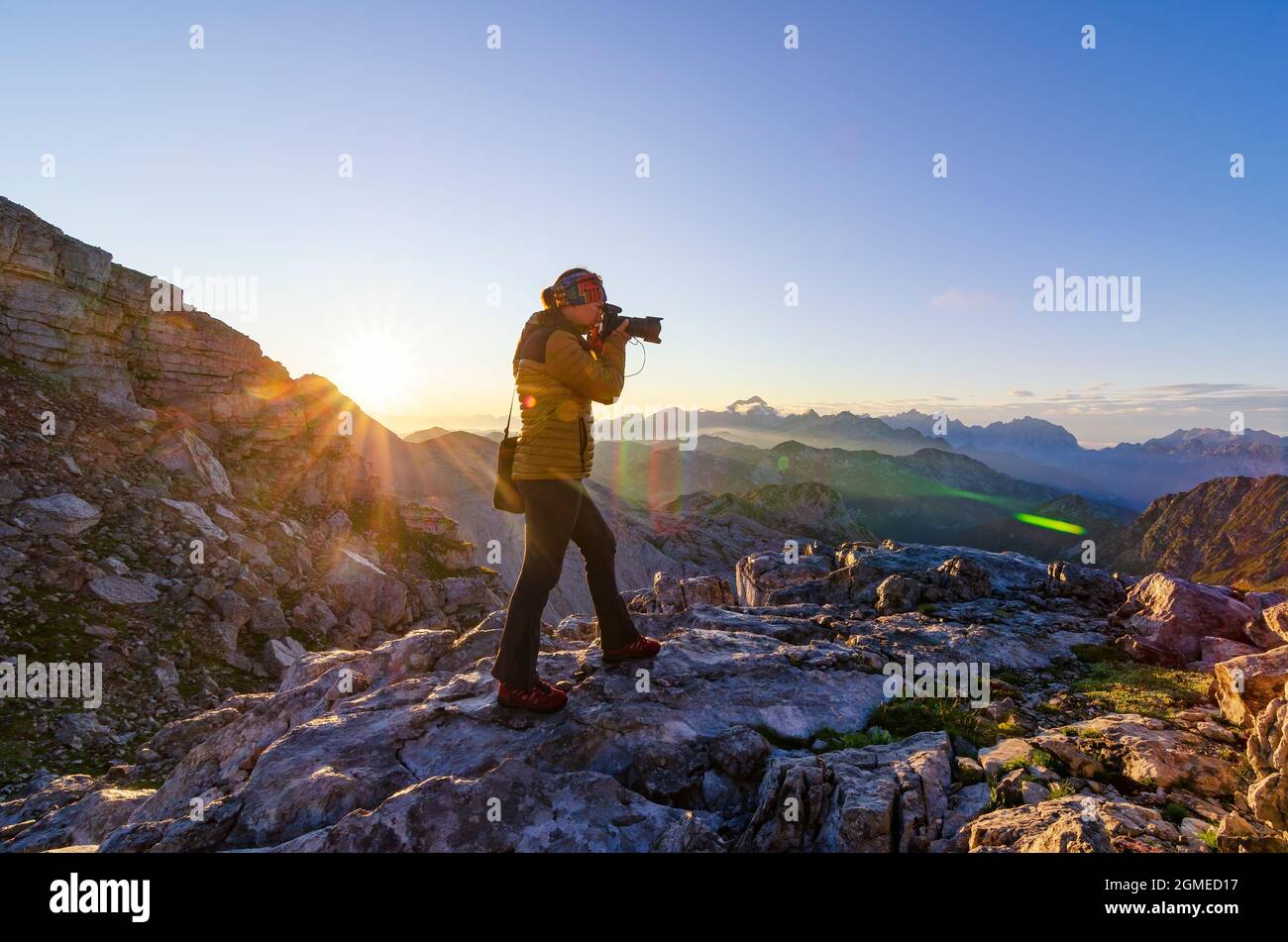 Fotografin macht Fotos auf dem Berggipfel. Outdoor-Aktivitäten, Wandern, Aktivurlaub und Wanderlust-Konzept. Stockfoto