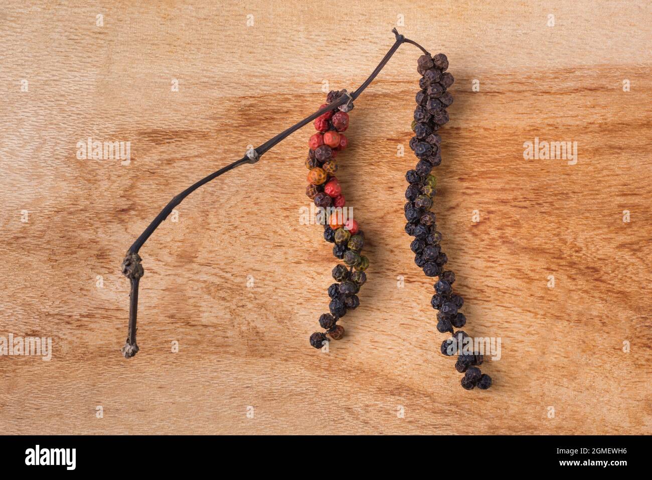 Getrocknete Pfefferkornerbeeren, würzige und würzige Zutat auf Holzoberfläche Hintergrund, Nahaufnahme von oben aufgenommen Stockfoto