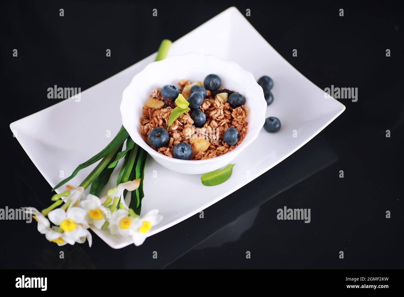 Ein gesundes Frühstück Müsli mit Milch und Obst. Hafer und Cornflakes mit Schokoladenjoghurt. Das Konzept der gesunden und vegetarischen Ernährung. Stockfoto