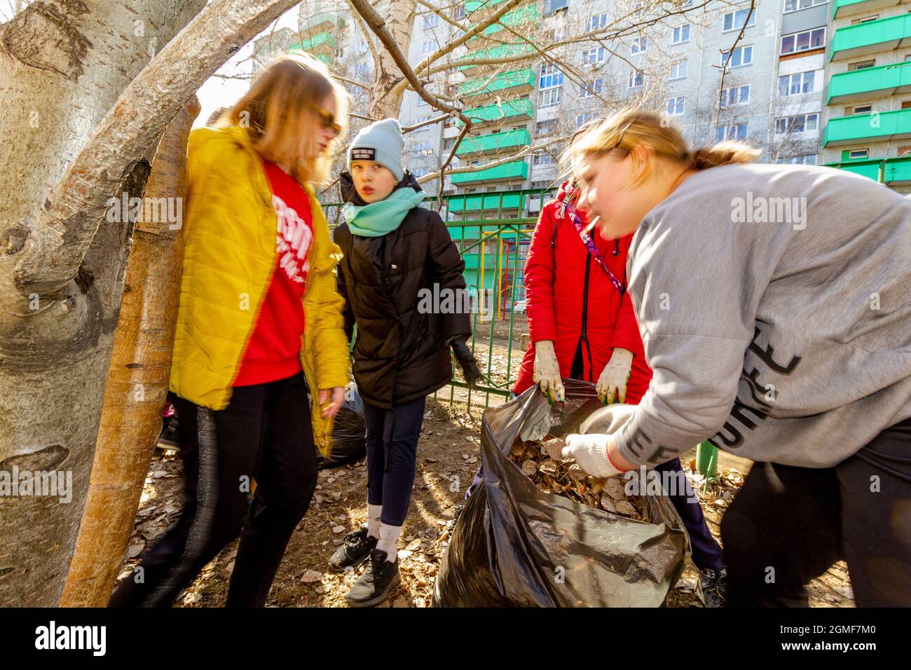 Omsk, Russland. 24. April 2021. Schülerinnen diskutieren über ihre Arbeit beim Reinigen des Schulgeländes. Traditionelle russische Veranstaltungen für die Vorbereitung der Schule terr Stockfoto