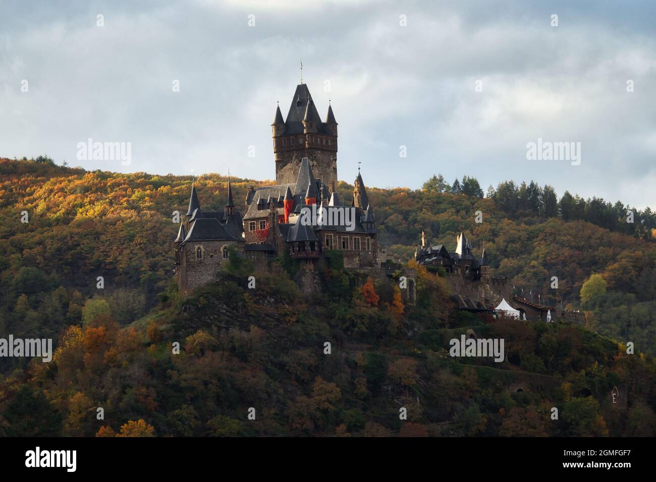 Schloss Cochem Reichsburg über der Mosel und Cochem, Deutschland, umgeben von bunten Bäumen an einem Herbsttag. Stockfoto