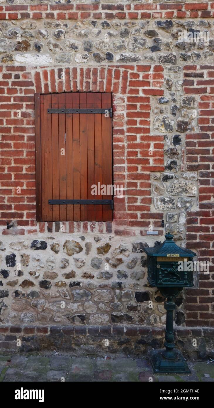 Alte Backsteinmauer mit Fenster und traditionellem Briefkasten, Honfleur, Frankreich Stockfoto