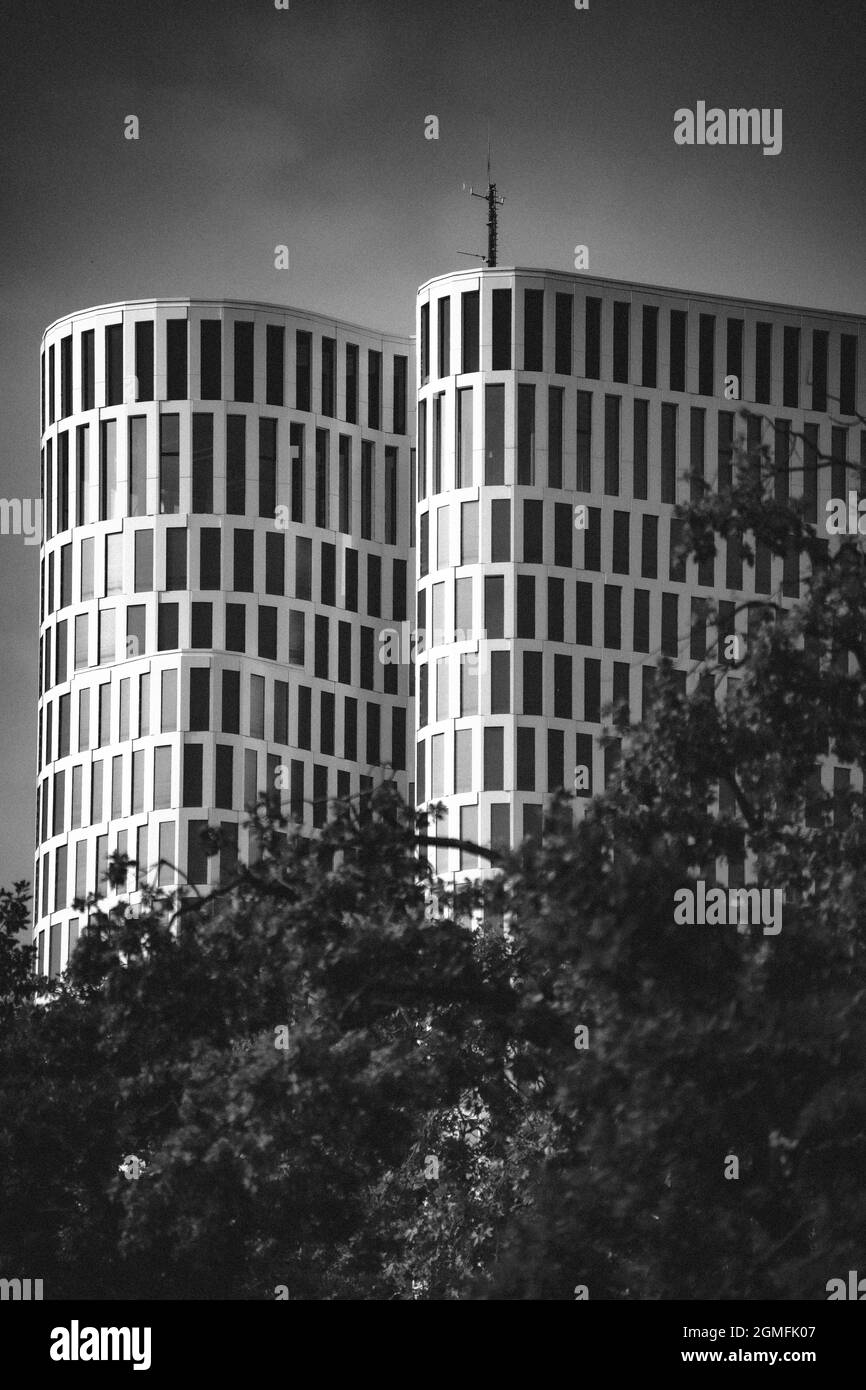 Moderne runde, hohe Gebäude mit Bäumen im Vordergrund Stockfoto