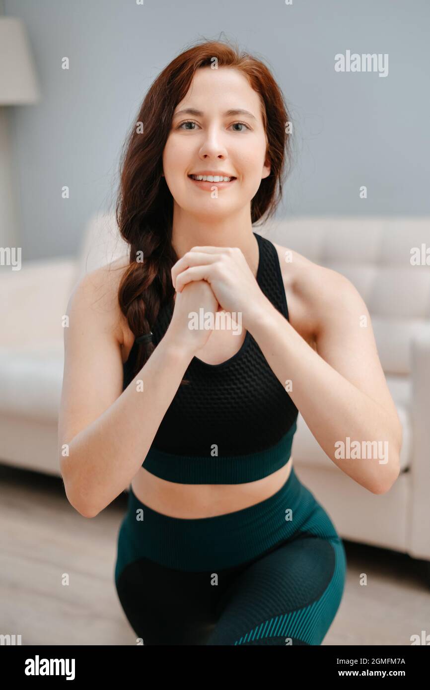 Frau in Sportkleidung macht Yoga zu Hause zum Stretching. Stockfoto