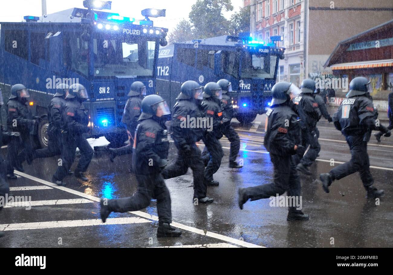 Leipzig, Deutschland. September 2021. Polizisten laufen über eine Kreuzung im Bezirk Connewitz. Nach dem offiziellen Ende der Demonstration „Wir sind alle LinX“ wurden im Leipziger Stadtteil Connewitz Barrikaden errichtet und in Brand gesetzt. Quelle: Sebastian Willnow/dpa-Zentralbild/dpa/Alamy Live News Stockfoto