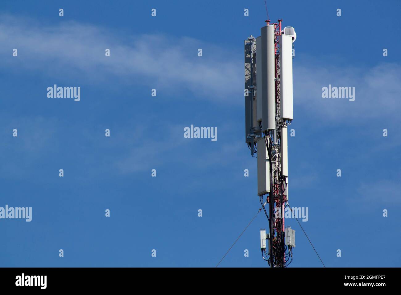 Handy-Turm vor dem Hintergrund eines blauen Himmels und einer weißen Wolke. Fernsehturm für Telekommunikation. Mobilfunkantenne. Wi-Fi-Sender Stockfoto