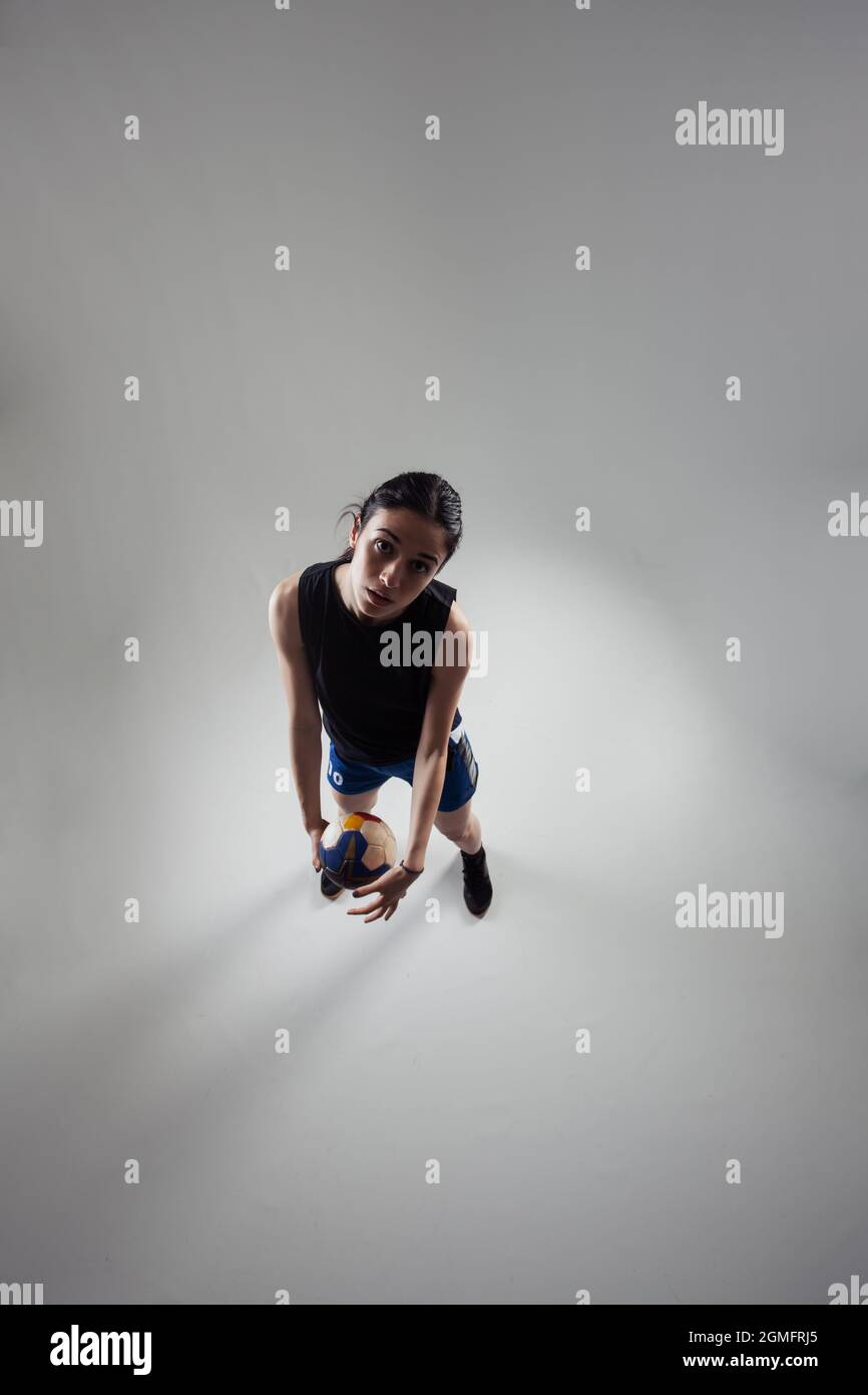 Handballspieler posiert auf hellgrauem Hintergrund. Mädchen posiert mit Ball. Stockfoto